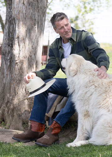 Man wearing Frye work shoes sitting with dog