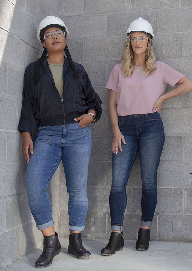 Two women wearing Rockport work shoes and hard hats